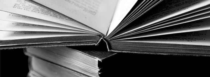 An open book stacked on closed books.