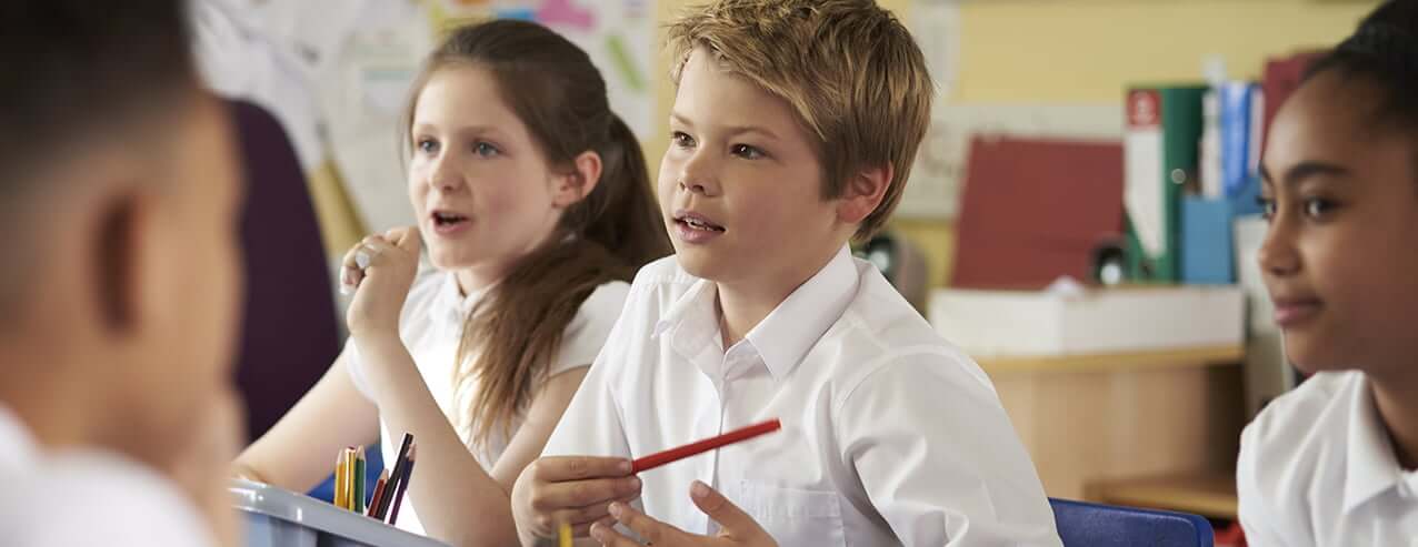 Primary school children at desks in classroom