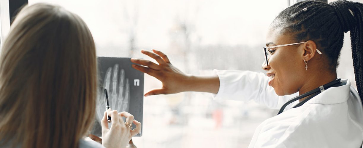 Medical professional investigating x-ray with colleague
