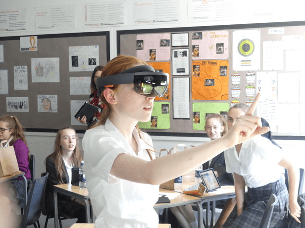 A school age girl wearing an augmented reality headset