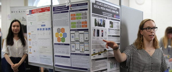 computing students standing next to academic posters they have made