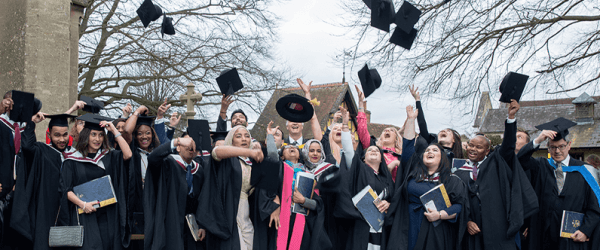 Graduates throwing graduation caps into the air