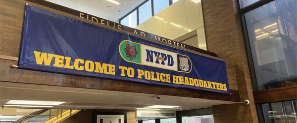 NYPD building with blue banner reading 'Welcome to the Police Headquarters'