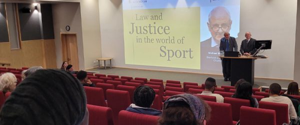 The Hon. Michael Beloff KC and The Vice Chancellor speaking in lecture theatre