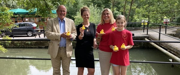 Duck Race organisers and competitors by the river with their rubber ducks