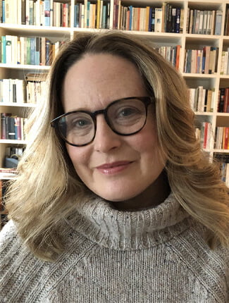 Portrait photograph of Ophelia Field, in front of bookcases