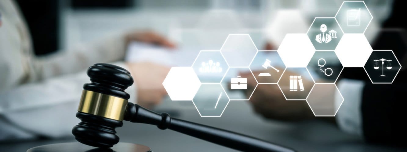 Legal desk with gavel and person working at laptop. Futuristic-style icons over image illustrating law and security