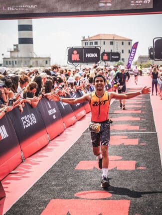 Samh running whilst crossing finish line during Ironman event
