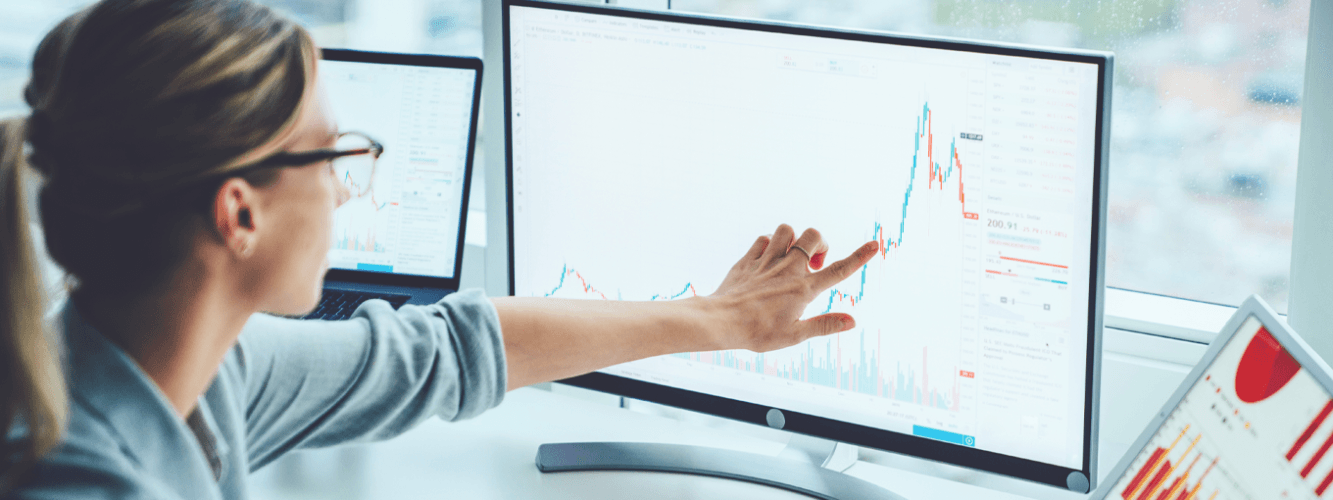 Woman pointing to point on graph in modern-style office setting
