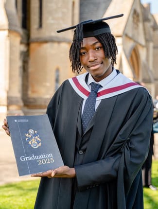 Bolu, on his day of graduation, holding the graduation brochure