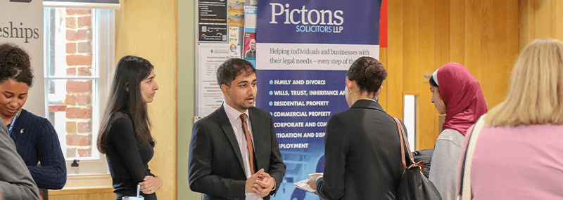 Representative of Pictons in Vinson Building talking to guest, at LawFest
