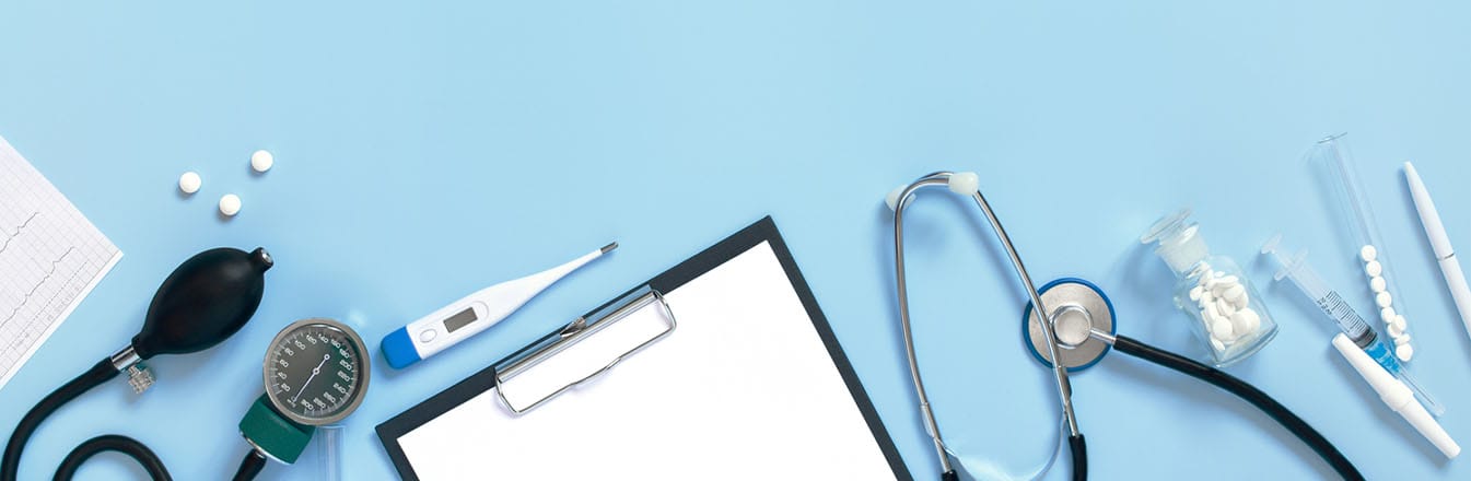 Blue surface top with medical equipment including thermometer, clipboard and stethoscope.