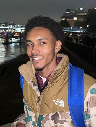 Ethan smiling for photo in front of cityscape