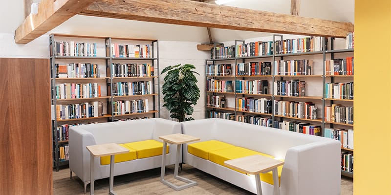 The Hunter Street Library: A bright space with bookshelves surrounding seating area with modern furnishings amongst a more traditional setting.